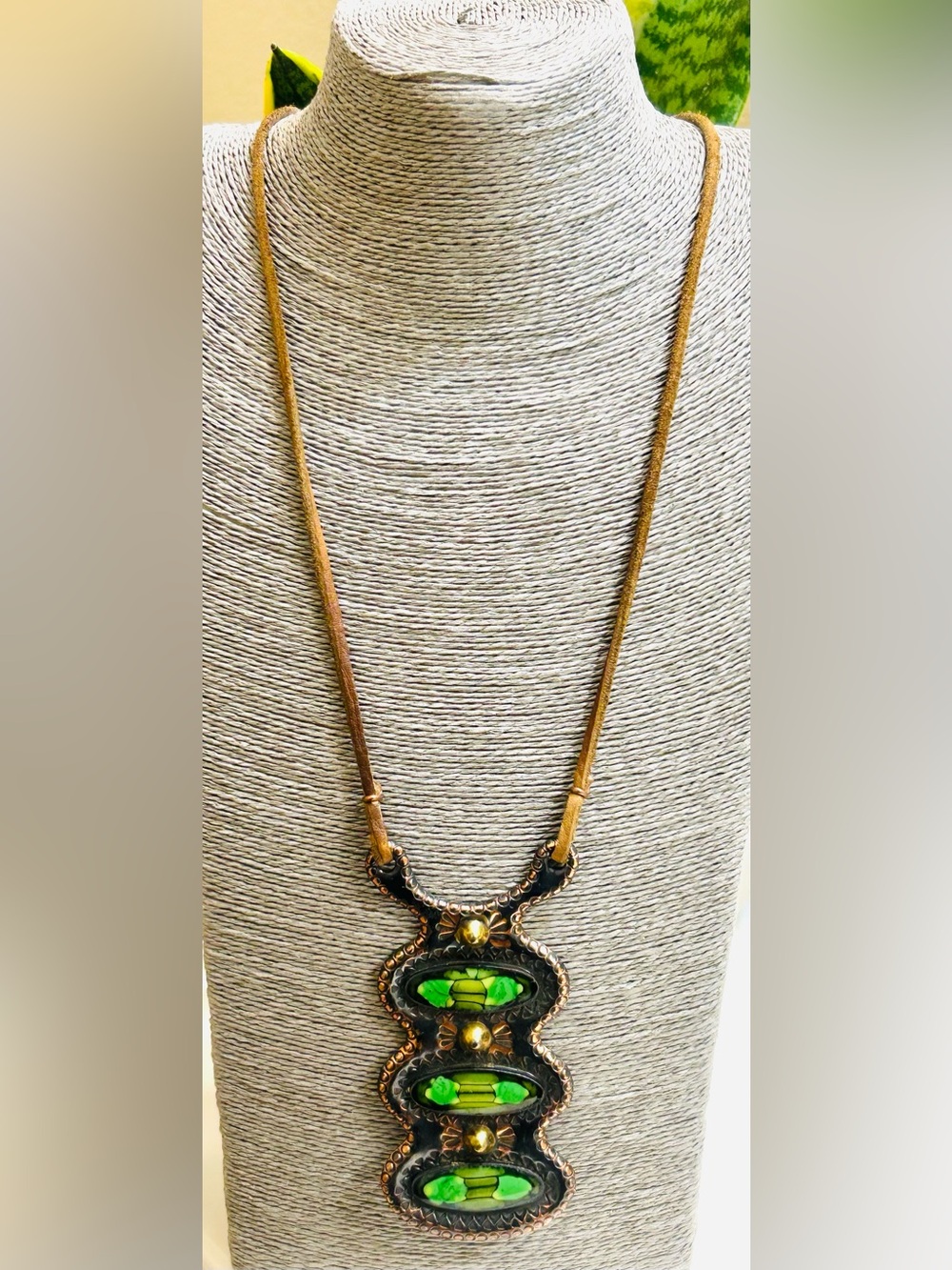 Artisanal pendant necklace features a textured, antiqued copper-finished metal